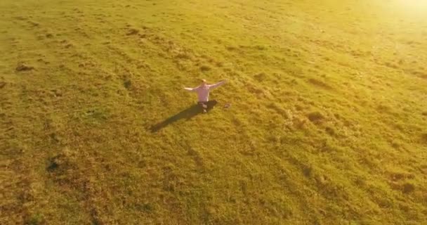 Basso volo orbitale intorno all'uomo su erba verde con blocco note al campo rurale giallo. — Video Stock