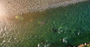 Güneşli yaz sabahında kayalarla birlikte taze, hızlı dağ nehri üzerinde alçak irtifa uçuşu..