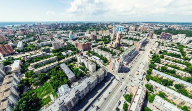 Kesişen yollar, evler, binalar, parklar ve otoparklar olan havacılık şehri manzarası. Güneşli yaz panoramik resmi