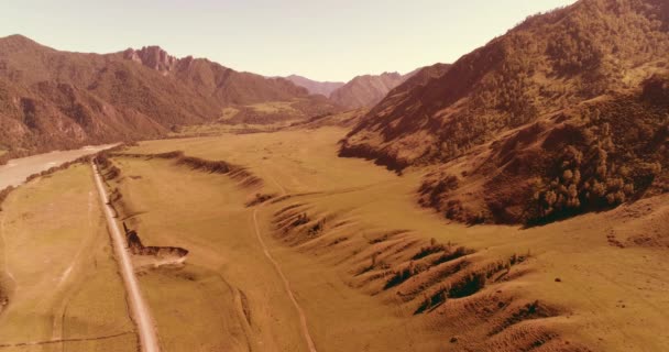 Route de montagne rurale aérienne et prairie au matin ensoleillé d'été. Asphalte autoroute et rivière. — Video