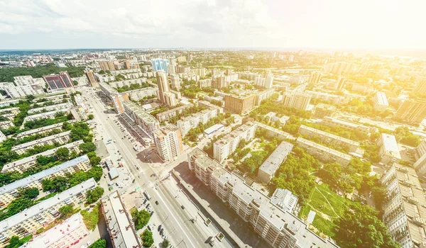 Uitzicht op de stad vanuit de lucht met kruispunten en wegen, huizen, gebouwen, parken en parkeerplaatsen. Zonnige zomer panoramisch beeld — Stockfoto