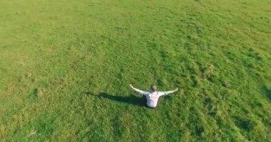 Yeşil çimlerin üzerinde sarı kırsal alanda not defteri olan bir adamın etrafında alçak yörünge uçuşları..