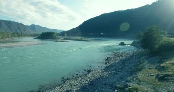 Vuelo de baja altitud sobre el río fresco de montaña rápida con rocas en la soleada mañana de verano. — Vídeo de stock