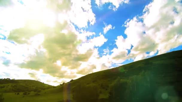 4K UHD prairie de montagne timelapse à l'été. Nuages, arbres, herbe verte et mouvement des rayons du soleil. — Video