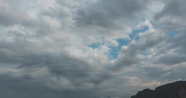 Kumsalda ve teknelerle deniz manzarasında yağmur bulutları hızlanıyor. Okyanusta tropik fırtına.