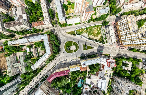 Vista aérea de la ciudad con encrucijadas y caminos, casas, edificios, parques y estacionamientos. Imagen panorámica soleada de verano — Foto de Stock