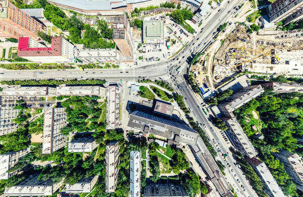 Aerial city view with crossroads and roads, houses, buildings, parks and parking lots, bridges. Helicopter drone shot. Wide Panoramic image.