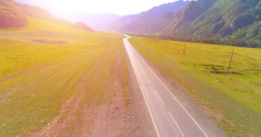 Dağda asfalt karayolu ve çayır üzerinde uçuş