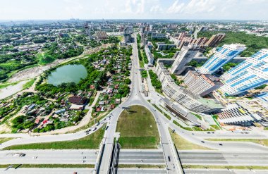 Kesişen yollar, evler, binalar, parklar ve otoparklar olan havacılık şehri manzarası. Güneşli yaz panoramik resmi