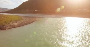 Güneşli yaz sabahında kayalarla birlikte taze, hızlı dağ nehri üzerinde alçak irtifa uçuşu..