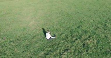 Yeşil çimlerin üzerinde sarı kırsal alanda not defteri olan bir adamın etrafında alçak yörünge uçuşları..