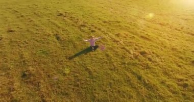 Yeşil çimlerin üzerinde sarı kırsal alanda not defteri olan bir adamın etrafında alçak yörünge uçuşları..