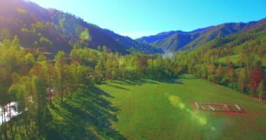 Güneşli yaz sabahında taze dağ nehri ve çayır üzerinde uçuşun ortasında. Aşağıdaki kırsal toprak yol.