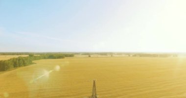 Yüksek voltajlı elektrik kulesi ve yeşil ve sarı alandaki elektrik hatları yakınında dikey hareket.