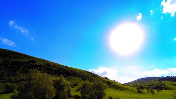 4K UHD montaña prado timelapse en el verano. Nubes, árboles, hierba verde y rayos de sol movimiento. — Vídeo de stock