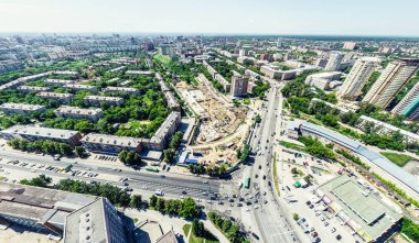 Kesişen yollar, evler, binalar, parklar ve otoparklar olan havacılık şehri manzarası. Güneşli yaz panoramik resmi