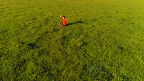 Vuelo radial de baja altitud sobre el hombre del yoga del deporte en hierba verde perfecta. Puesta de sol en montaña. — Vídeos de Stock
