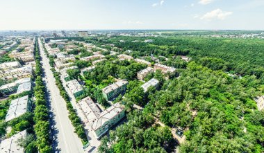 Kesişen yollar, evler, binalar, parklar ve otoparklar olan havacılık şehri manzarası. Güneşli yaz panoramik resmi