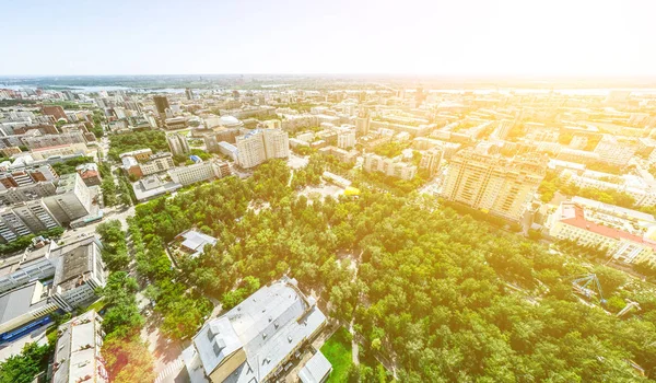 Aerial city view with crossroads and roads, houses, buildings, parks and parking lots. Sunny summer panoramic image — Stock Photo, Image