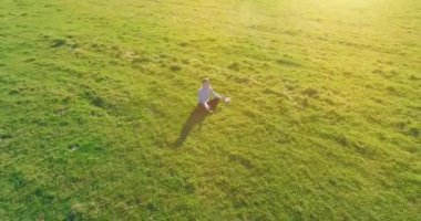 Yeşil çimlerin üzerinde sarı kırsal alanda not defteri olan bir adamın etrafında alçak yörünge uçuşları..