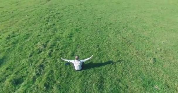 Alacsony orbitális repülés körül férfi zöld füvön notebook pad sárga vidéki területen. — Stock videók