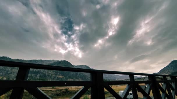 Timelapse van houten hek op hoog terras bij berglandschap met wolken. Horizontale schuifbeweging — Stockvideo