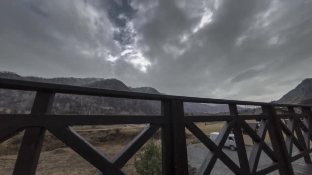 Timelapse drewnianego ogrodzenia na wysokim tarasie w górskim krajobrazie z chmurami. Poziomy ruch suwaka — Wideo stockowe