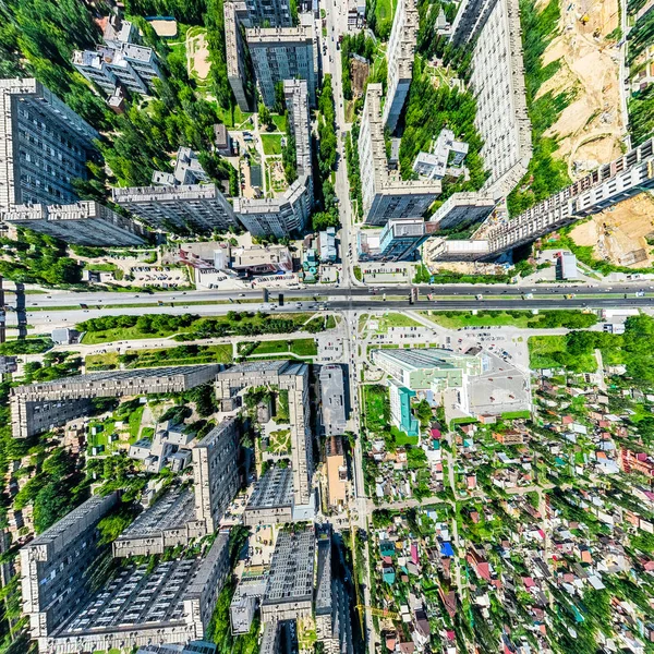 Vista aérea de la ciudad con encrucijadas y caminos, casas, edificios, parques y estacionamientos. Imagen panorámica soleada de verano — Foto de Stock