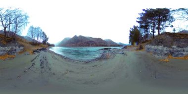 Sonbaharın sonlarında güzel bir dağ nehrinin görüntüsü. Ulusal park, çayır, bulutlu bir günde nehir kıyısı.