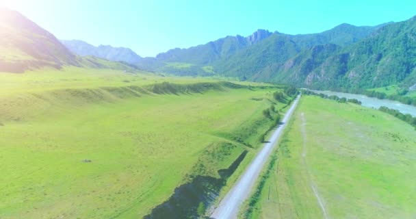 Camino de montaña rural aéreo y prado en la soleada mañana de verano. Autopista del asfalto y río. — Vídeos de Stock