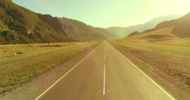 Tiefflug über Bergstraße und Wiese bei sonnigem Sommermorgen. — Stockvideo