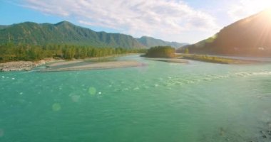 Güneşli yaz sabahında kayalarla birlikte taze, hızlı dağ nehri üzerinde alçak irtifa uçuşu..