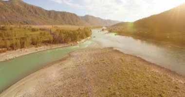 Güneşli yaz sabahında kayalarla birlikte taze, hızlı dağ nehri üzerinde alçak irtifa uçuşu..