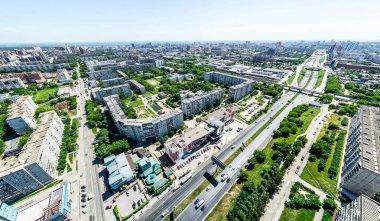Kesişen yollar, evler, binalar, parklar ve otoparklar olan havacılık şehri manzarası. Güneşli yaz panoramik resmi