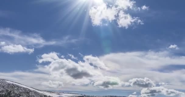 Tijdsverloop van het wolkenlandschap achter de bergtop. Sneeuw, rotsen, kliffen en een diepblauwe lucht. Hoge hoogte. — Stockvideo