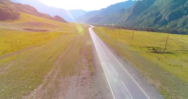 เที่ยวบินเหนือภูเขายางมะตอยถนนทางหลวงและทุ่งหญ้า — วีดีโอสต็อก