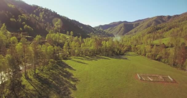 Mid air flygning över färska berg flod och äng på solig sommarmorgon. Landsbygdsvägen nedanför. — Stockvideo