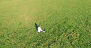 Yeşil çimlerin üzerinde sarı kırsal alanda not defteri olan bir adamın etrafında alçak yörünge uçuşları..