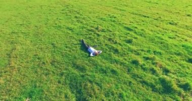 Yeşil çimlerin üzerinde sarı kırsal alanda not defteri olan bir adamın etrafında alçak yörünge uçuşları..