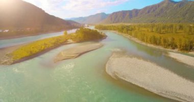 Güneşli yaz sabahında kayalarla birlikte taze, hızlı dağ nehri üzerinde alçak irtifa uçuşu..