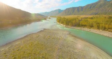 Güneşli yaz sabahında kayalarla birlikte taze, hızlı dağ nehri üzerinde alçak irtifa uçuşu..