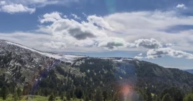 Dağların arkasındaki bulutların zaman çizelgesi. Kar, kayalar, uçurumlar ve derin mavi gökyüzü. Yüksek irtifa.
