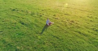 Yeşil çimlerin üzerinde sarı kırsal alanda not defteri olan bir adamın etrafında alçak yörünge uçuşları..