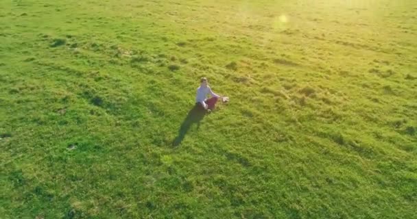 Basso volo orbitale intorno all'uomo su erba verde con blocco note al campo rurale giallo. — Video Stock