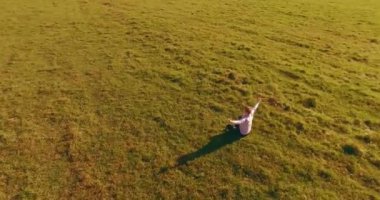 Yeşil çimlerin üzerinde sarı kırsal alanda not defteri olan bir adamın etrafında alçak yörünge uçuşları..