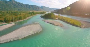 Güneşli yaz sabahında kayalarla birlikte taze, hızlı dağ nehri üzerinde alçak irtifa uçuşu..