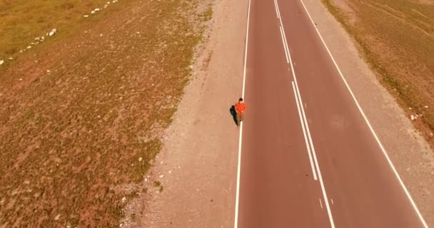 Vôo de baixa altitude sobre homem desportivo em nova estrada de asfalto — Vídeo de Stock