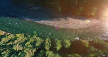 Güneşli yaz sabahında kayalarla birlikte taze, hızlı dağ nehri üzerinde alçak irtifa uçuşu..