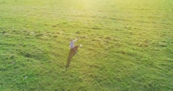 Matala kiertoradalla lento miehen vihreä ruoho kannettavan pad keltainen maaseudun kenttä. — kuvapankkivideo