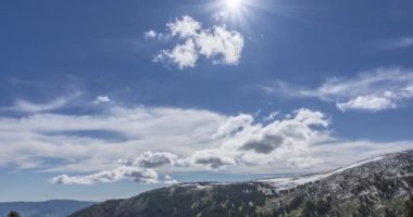 Dağların arkasındaki bulutların zaman çizelgesi. Kar, kayalar, uçurumlar ve derin mavi gökyüzü. Yüksek irtifa.